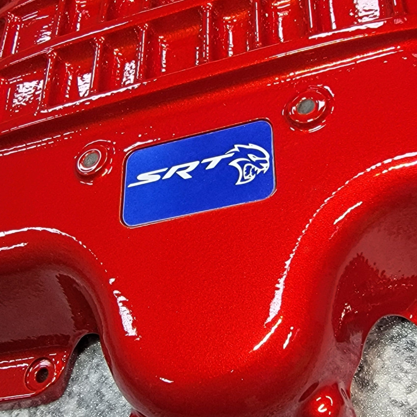 Customer picture: Close-up of our Blue Hellcat supercharger lid badge on an Red lid.
